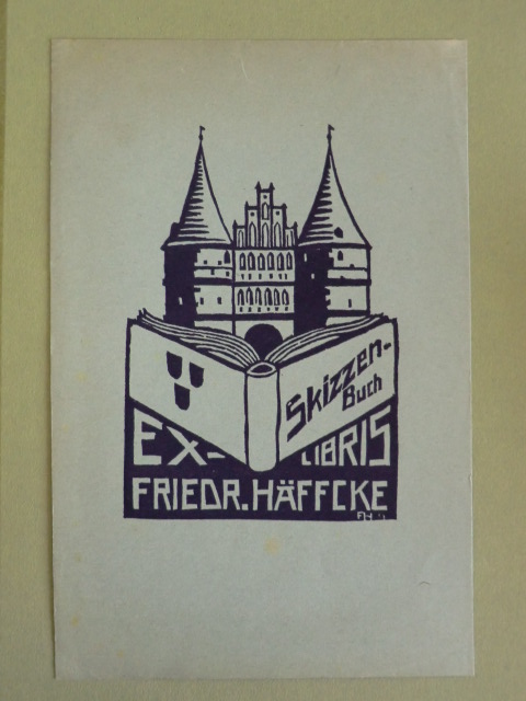 Häffcke, Friedrich:  Exlibris Friedrich Häffcke. Motiv: Das Holstentor zu Lübeck. Davor ein aufgeschlagenes Buch mit der Aufschrift Skizzen-Buch 